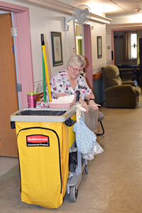 Image of woman with a houskeeping cart.